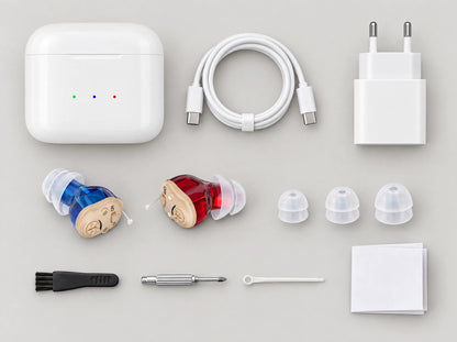 Le contenu de la boîte vu de dessus : boîtier de charge, câble USB-C et adaptateur secteur, deux appareils, trois embouts en silicone (S, M, L), brosse, tournevis, cure-cérumen et livret